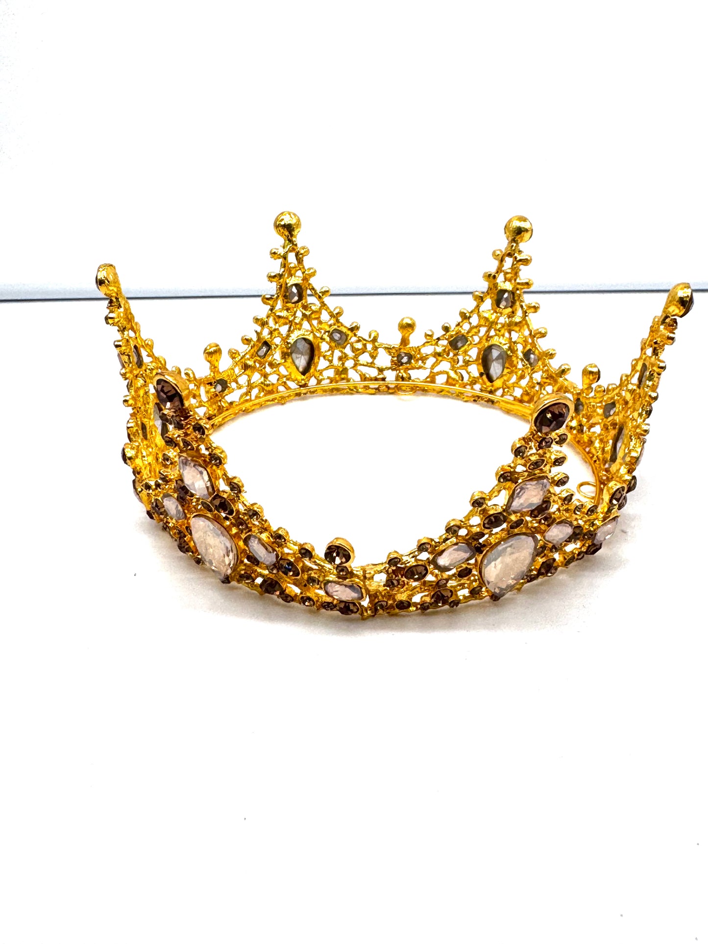 Gold crown with gemstones on a white background
